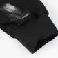 Close-up of a black hoodie sleeve with a silver graffiti print and ribbed cuff.