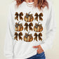A woman wears a white long-sleeve sweatshirt with a pumpkin and bow graphic.