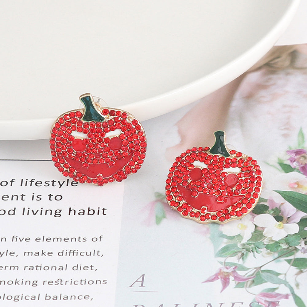 A pair of red rhinestone pumpkin earrings with a jack-o'-lantern face.