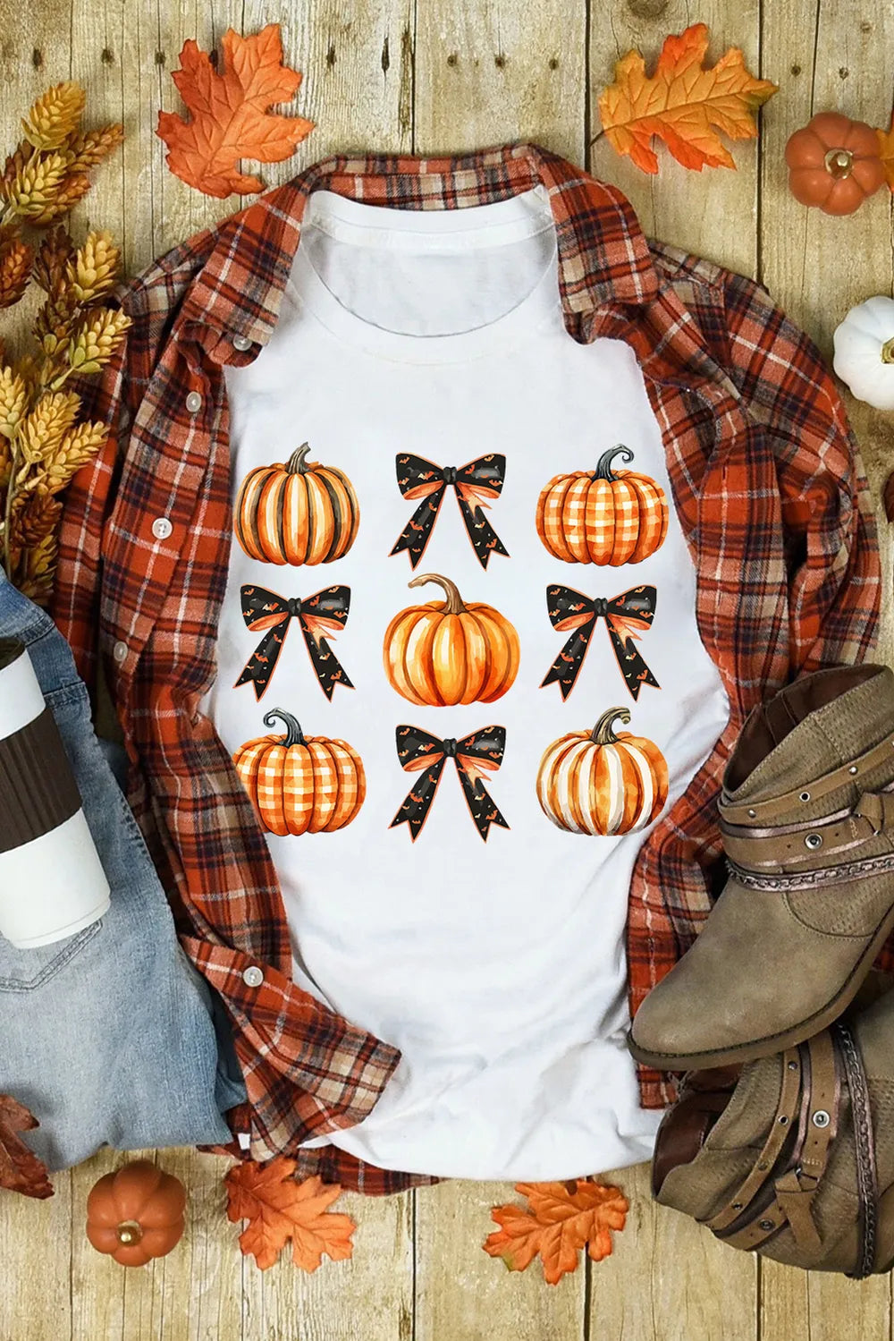 A white short-sleeve t-shirt with pumpkin and Halloween bow graphics.
