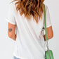 A woman from behind wears a white short-sleeve t-shirt and light wash jeans.