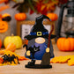 A wooden Halloween gnome ornament with a witch hat, black cat, and broom.