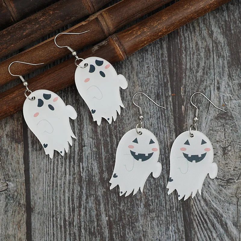 Four ghost-shaped dangle earrings, two with black eyes and pink cheeks, and two with smiling jack-o'-lantern faces.