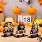 Three car-shaped Halloween ornaments featuring gnomes, pumpkins, and ghosts.