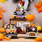 Three Halloween car-shaped ornaments featuring gnomes, pumpkins, and ghosts.