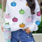 White long-sleeve sweatshirt with colorful sequin pumpkins and distressed denim shorts.